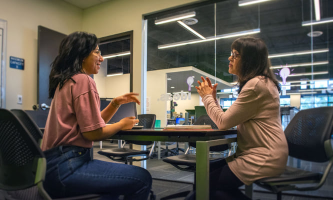 Two people talking while sitting at a table